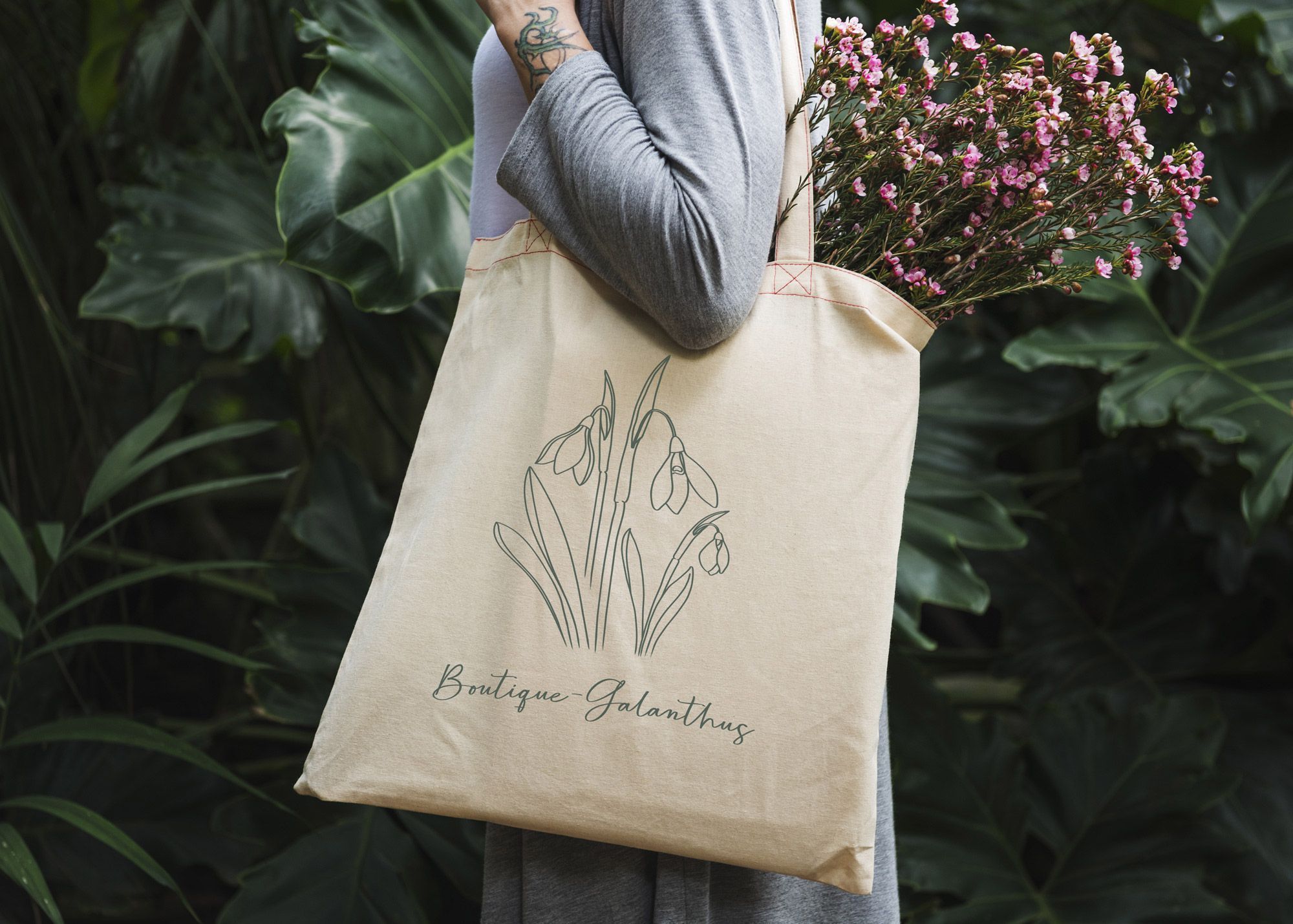 Boutique-Galanthus logo vist på mulepose, som en kvinde går med